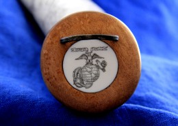 An artificial ivory medallion engraved with the USMC insigniais inlaid into the turned cherry butt plug